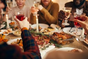 raising glasses at holiday dinner party